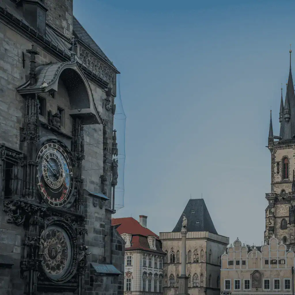 The historic quarter of Prague - A photograph of the Astronomical Clock in Prague and church towers in the background, under clear skies.